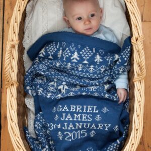 People & Trees personalised baby blanket in HOLKHAM colourway with baby in moses basket